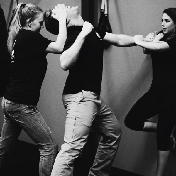Self-defense training with three participants.
